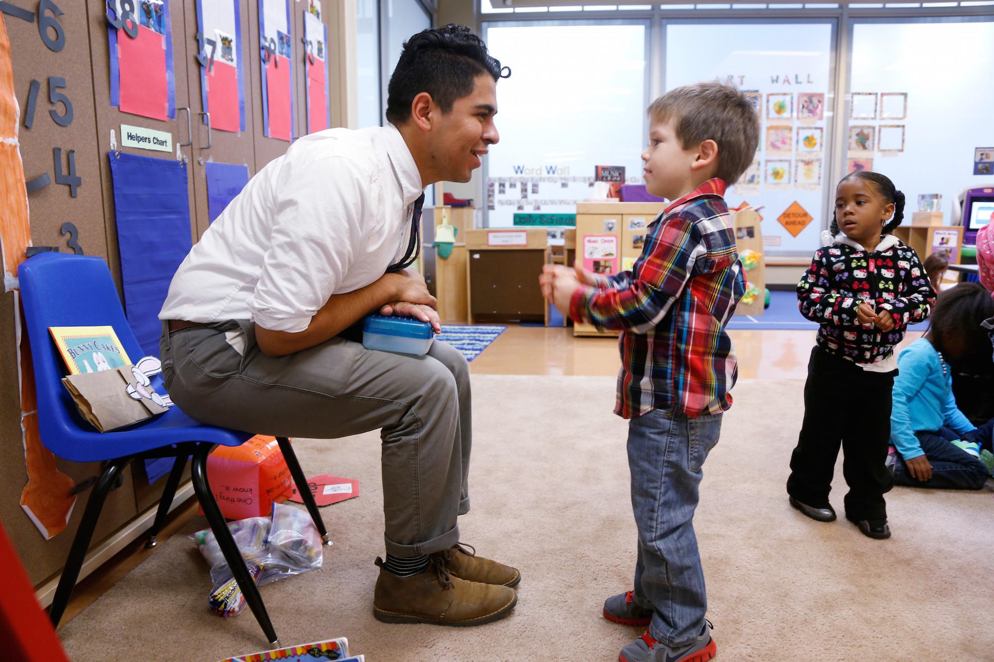 A TFA teacher talks with his young student
