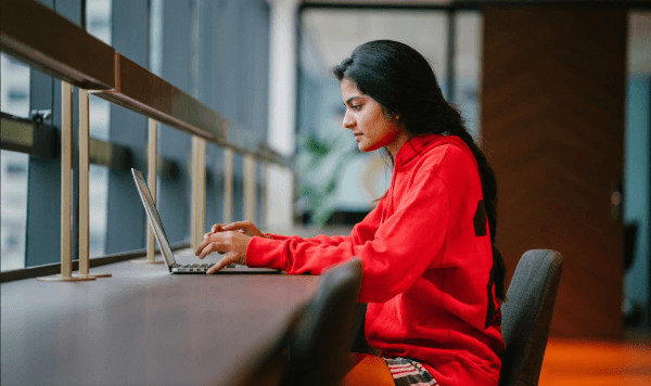 Female student registering for test on laptop